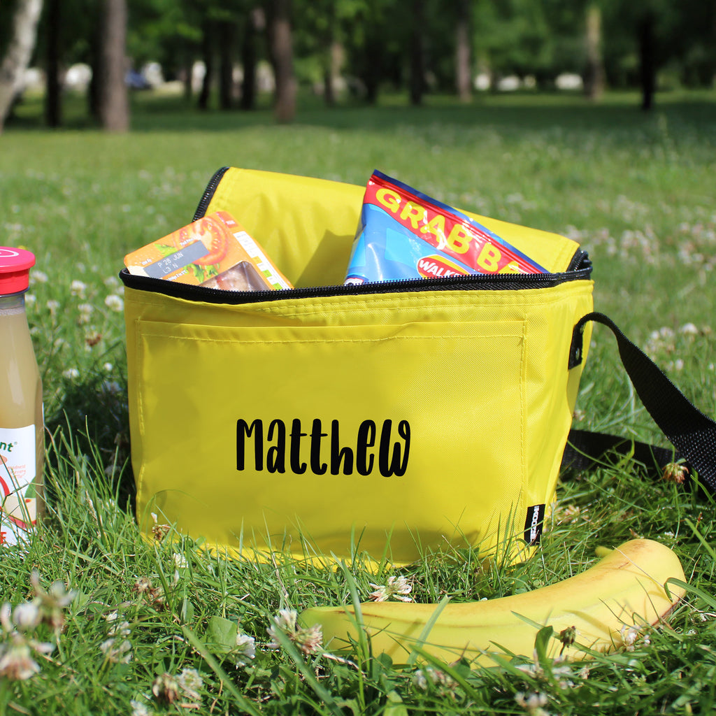 Yellow bag with snacks and a drink on grass