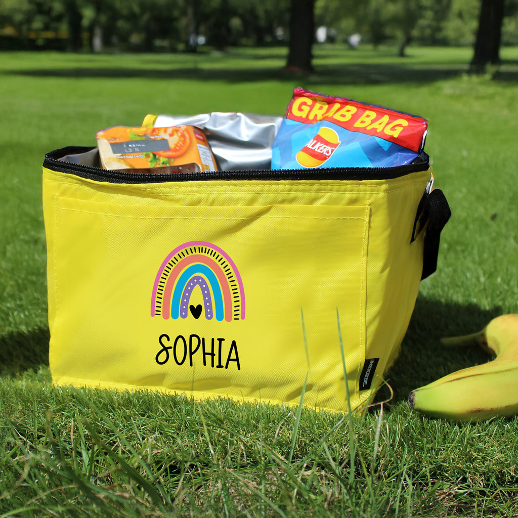 Yellow cooler bag with 'SOPHIA' on it, filled with snacks, on grass