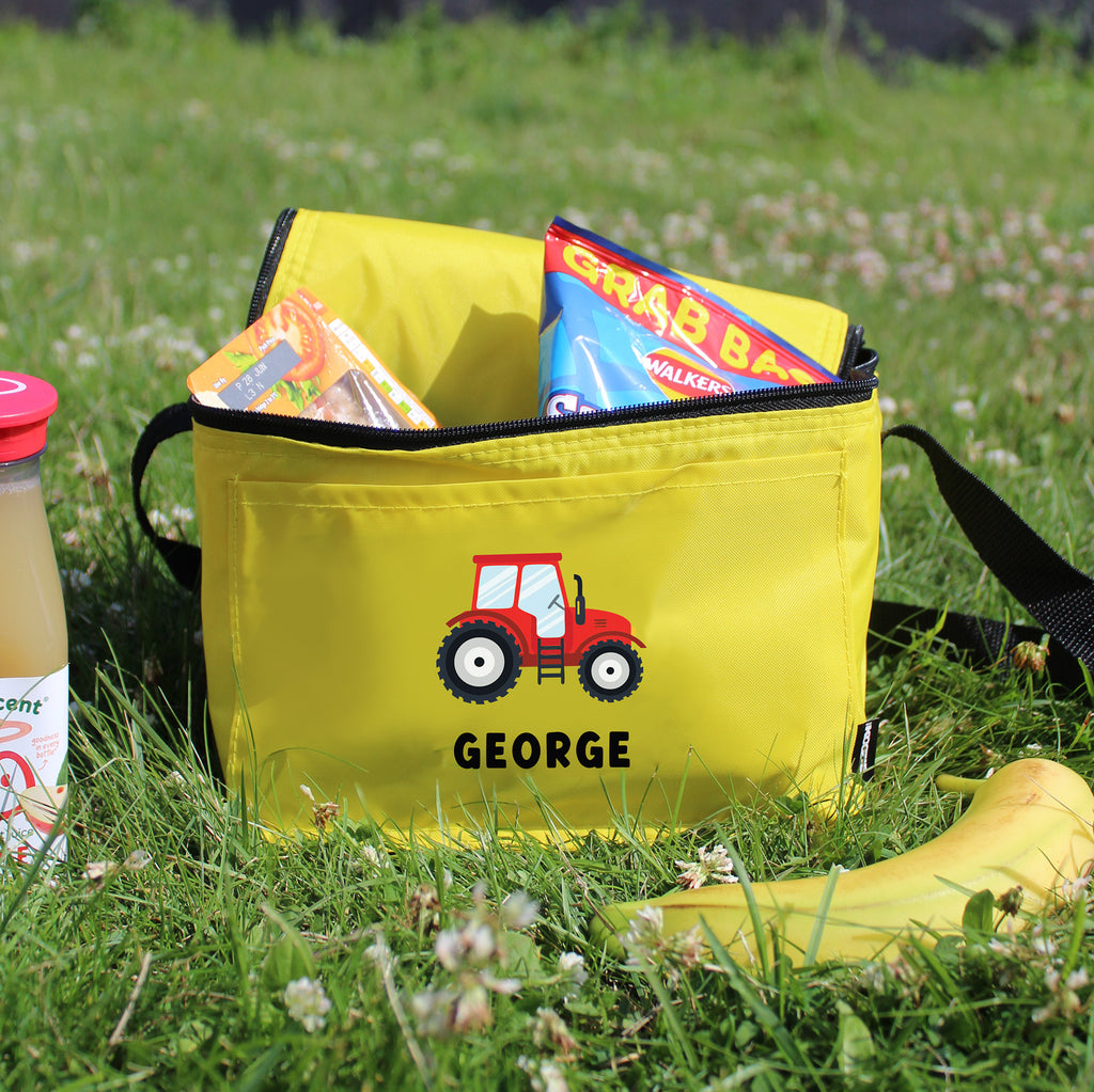 Yellow bag with a red tractor design and 'GEORGE' text on grass