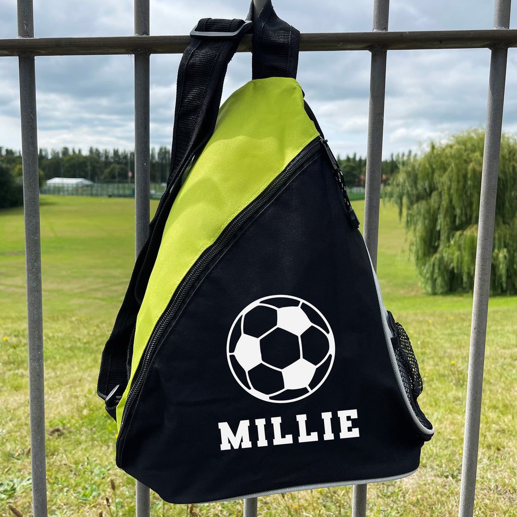 Sling bag with soccer ball design and 'MILLIE' text on a grassy field background