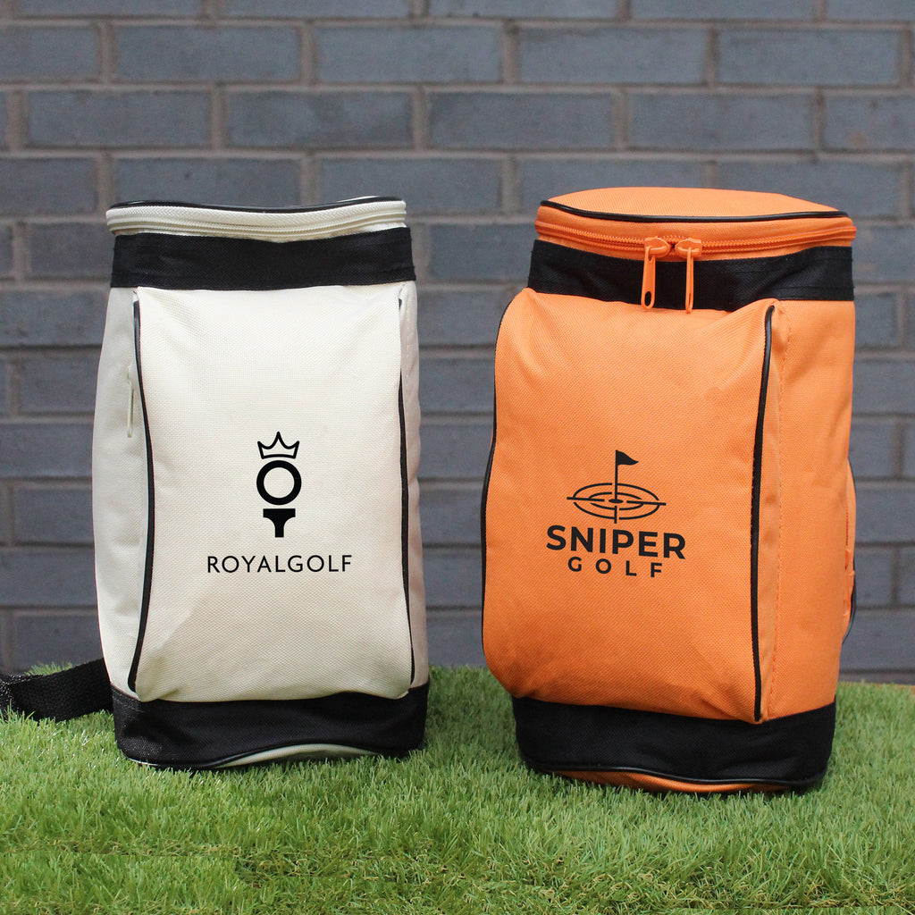 Two golf bags, one white and one orange, with 'ROYALGOLF' and 'SNIPER GOLF' logos against a brick wall.