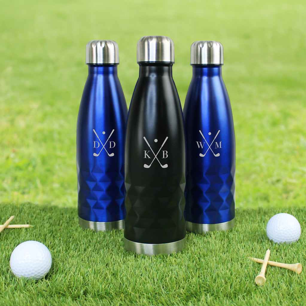 Three insulated water bottles with monograms on a grass background with golf balls and tees.