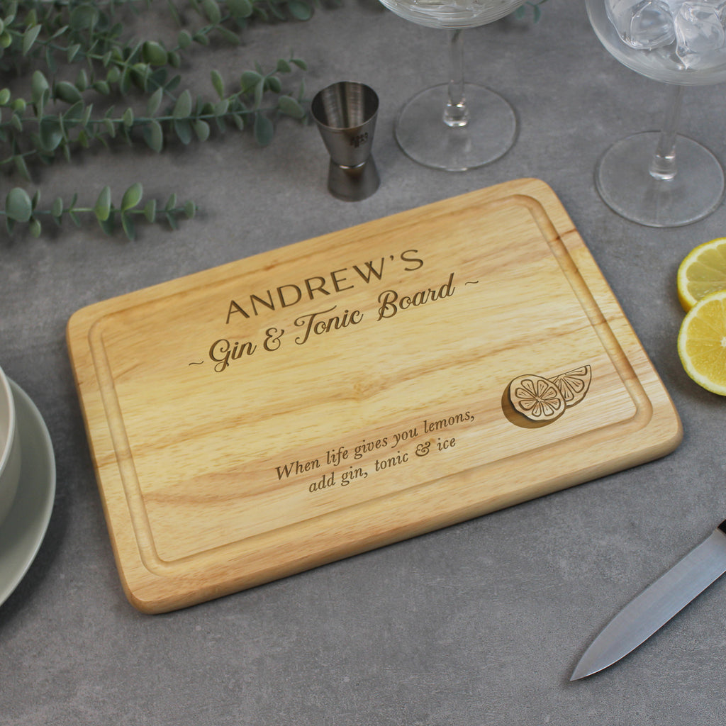 Personalized wooden cutting board with engraved text on a table with glasses and lemons.