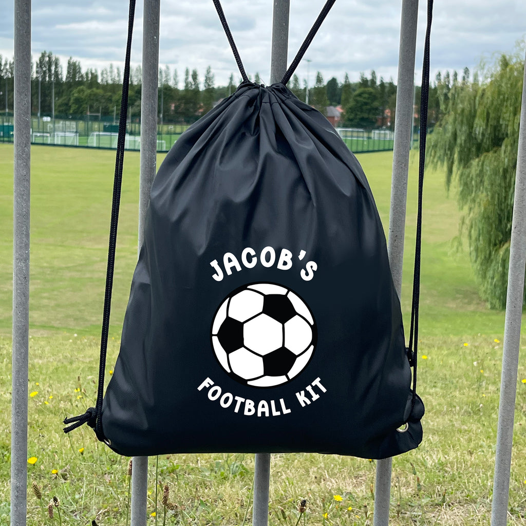 Black drawstring bag with 'Jacob's Football Kit' text and soccer ball graphic on a grassy field background.