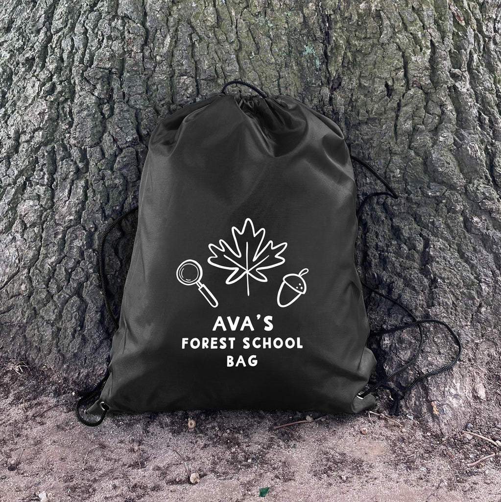 Black drawstring bag with 'Ava's Forest School Bag' text and nature-themed graphics on a tree trunk.