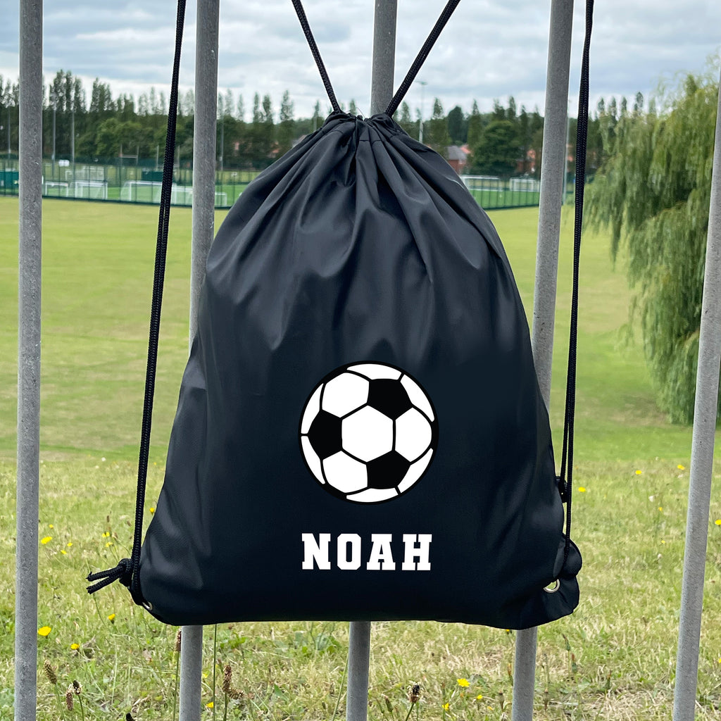 Black drawstring bag with soccer ball design and 'NOAH' text on a grassy field.