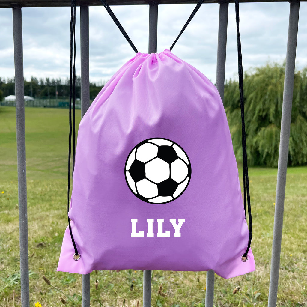 Purple drawstring bag with soccer ball design and 'LILY' text, placed against a grassy field background.