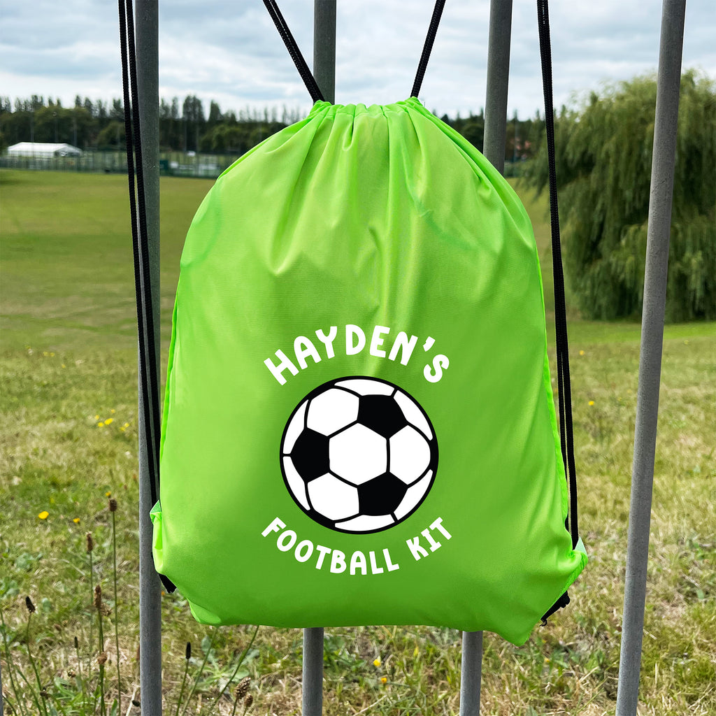Green drawstring bag with soccer ball design and 'Hayden's Football Kit' text on a grassy field background.