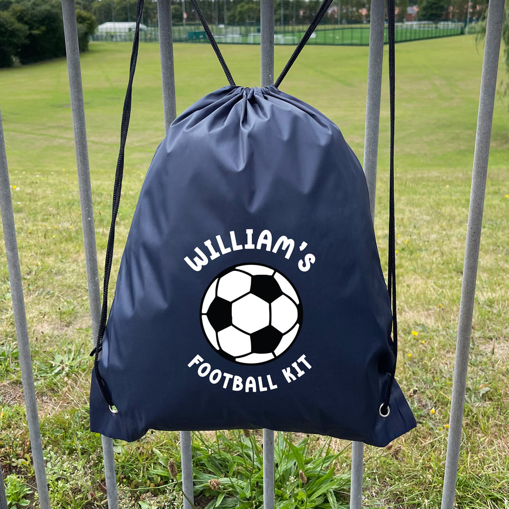 Navy drawstring bag with soccer ball design and 'William's Football Kit' text on a grassy field background.