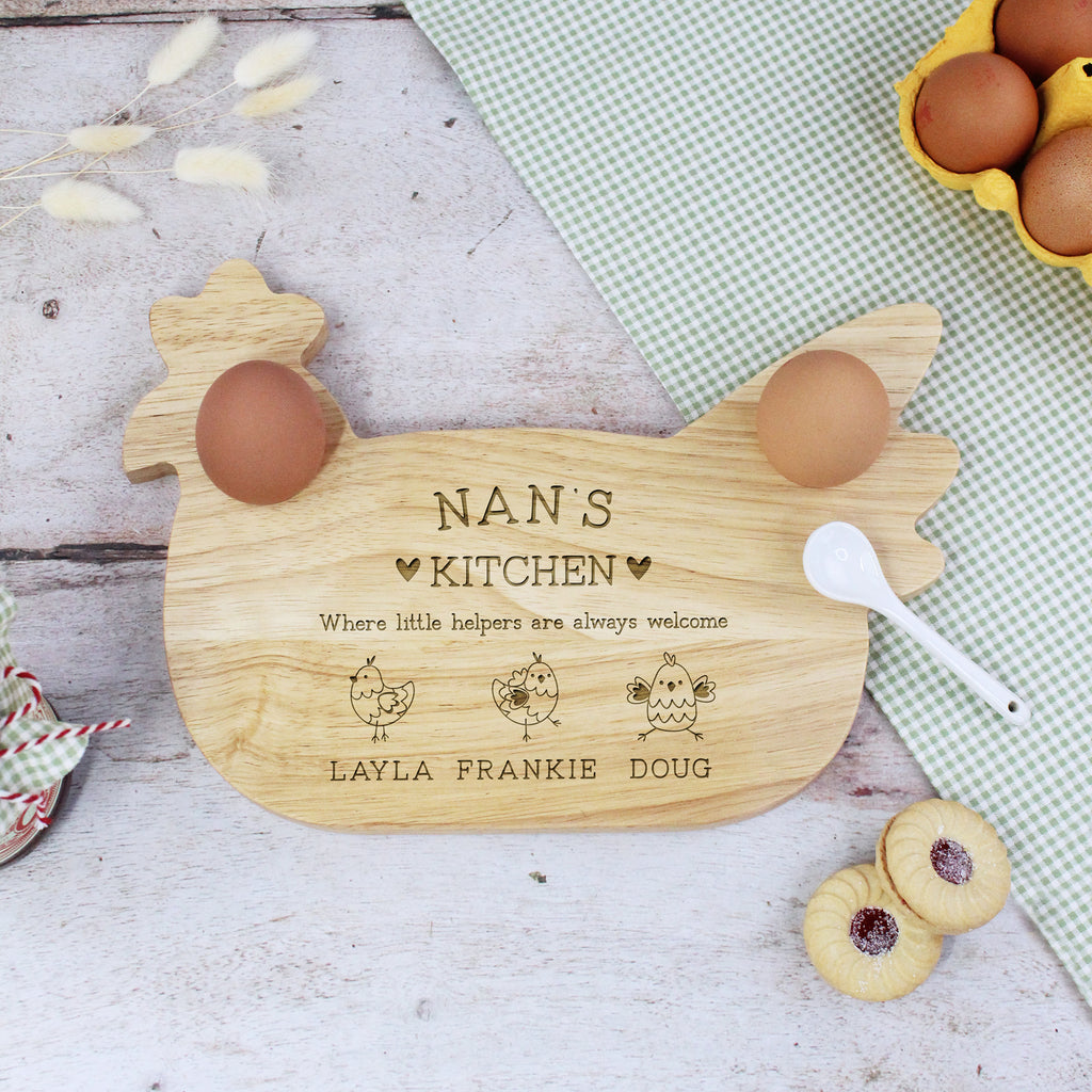 Wooden chicken-shaped cutting board with engraved text on a rustic wooden surface.