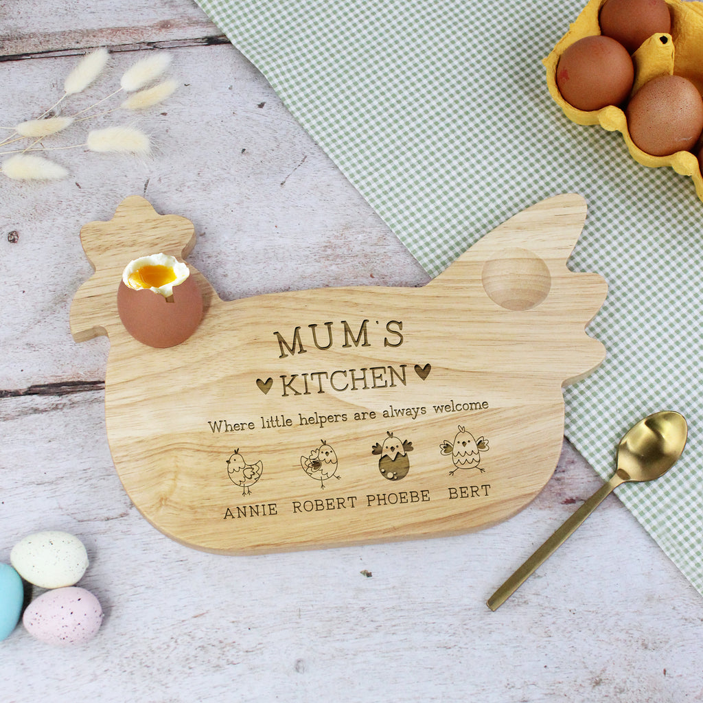 Wooden chicken-shaped cutting board with engraved text on a kitchen counter.