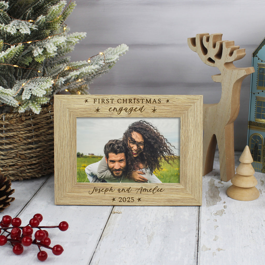 Personalized wooden photo frame with a couple's photo and text, placed on a festive background with a Christmas tree and decorations.