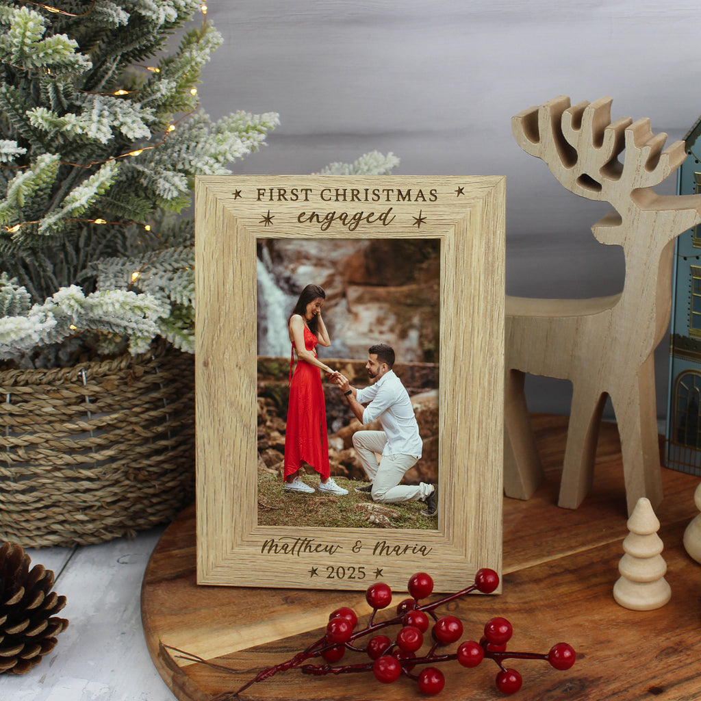 Wooden photo frame with engraved text, placed on a surface with decorative items.