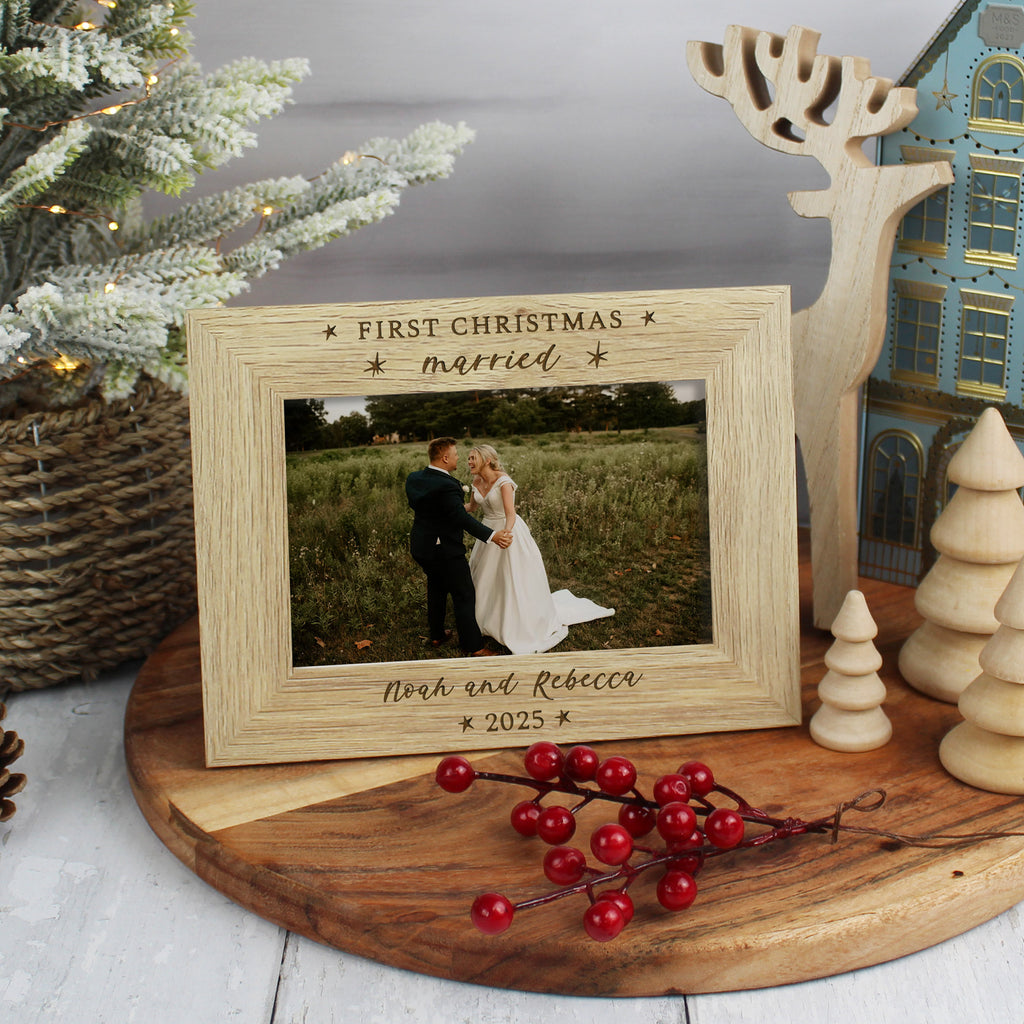 Wooden photo frame with a couple's wedding photo, surrounded by Christmas decorations.