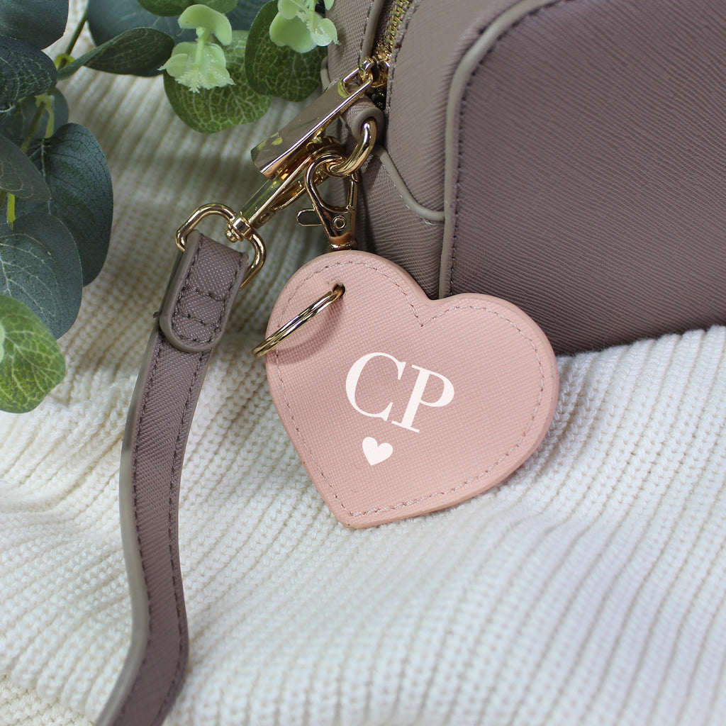 Heart-shaped keychain with 'CP' initials attached to a bag