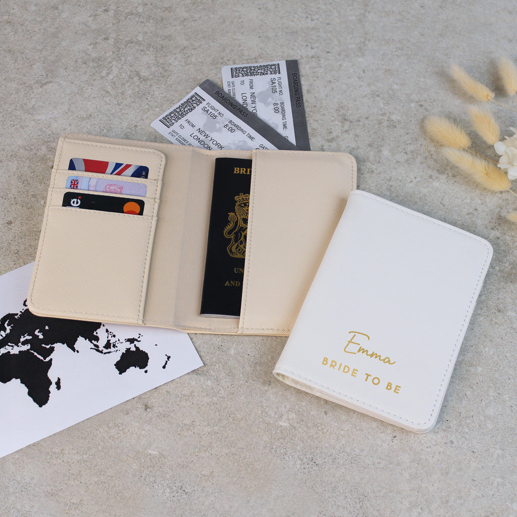 Beige passport holder with a passport and cards on a gray surface with a world map.