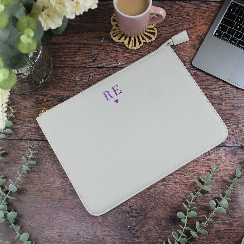White mouse pad with 'RE' logo on a wooden desk with laptop, mug, and flowers.