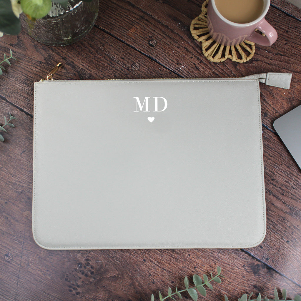 Light gray pouch with 'MD' initials on a wooden surface with a mug and plant.