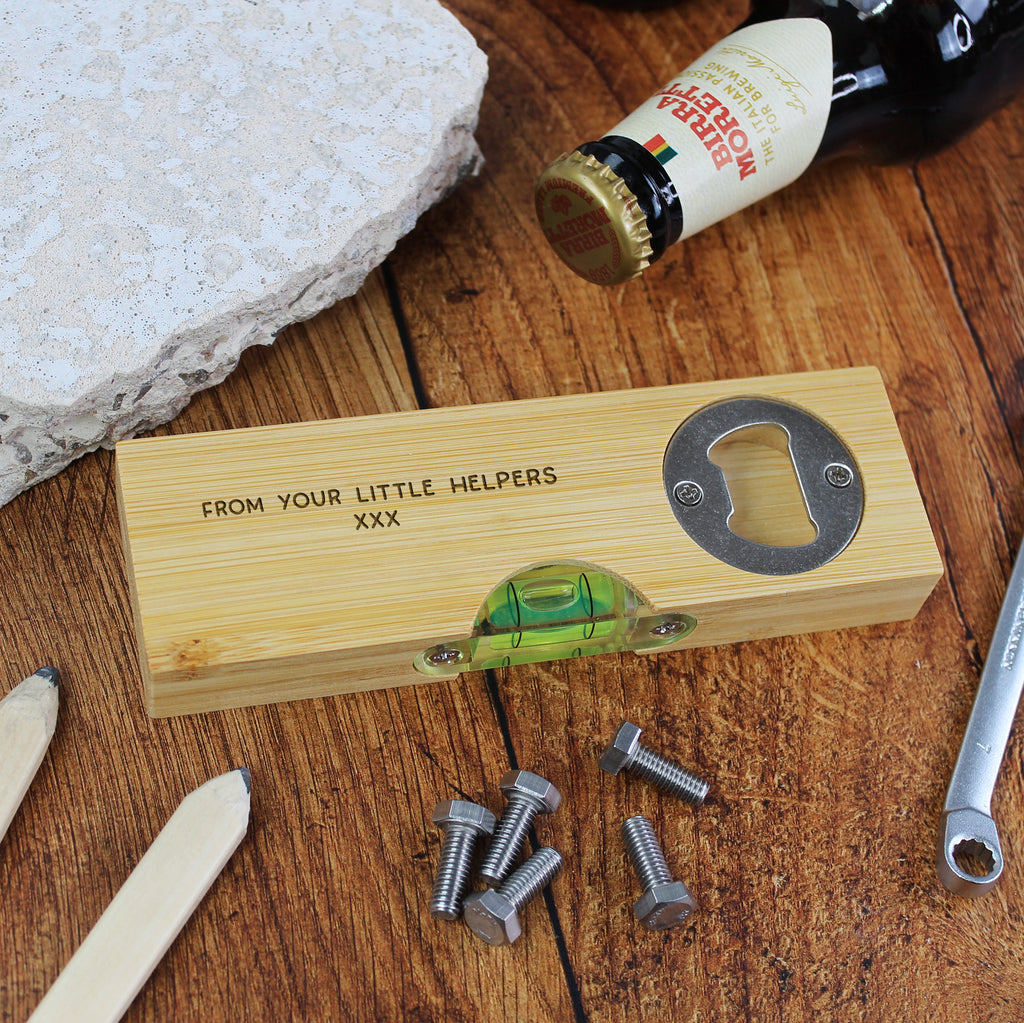 Wooden box with bottle opener, level, and screws on a wooden surface with a bottle in the background.
