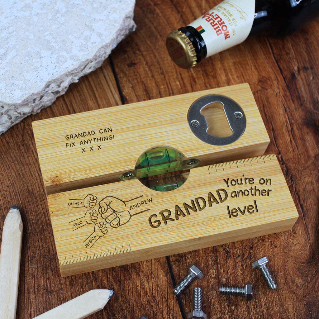 Wooden bottle opener with engraved text on a wooden surface with tools and a beer bottle.