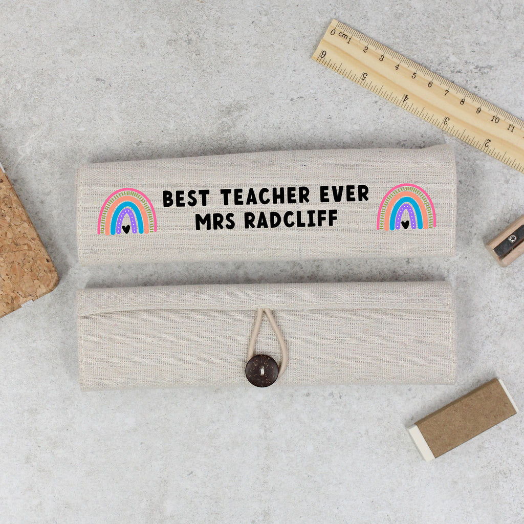 Personalized pencil case with 'Best Teacher Ever Mrs Radcliff' text and rainbow designs on a gray surface.