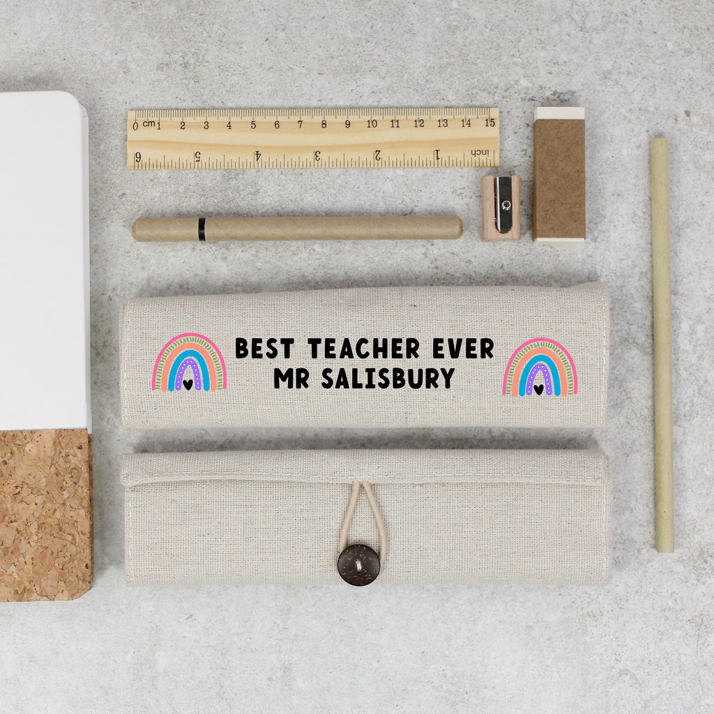 Pencil case with 'Best Teacher Ever Mr Salisbury' text and stationery items on a concrete surface