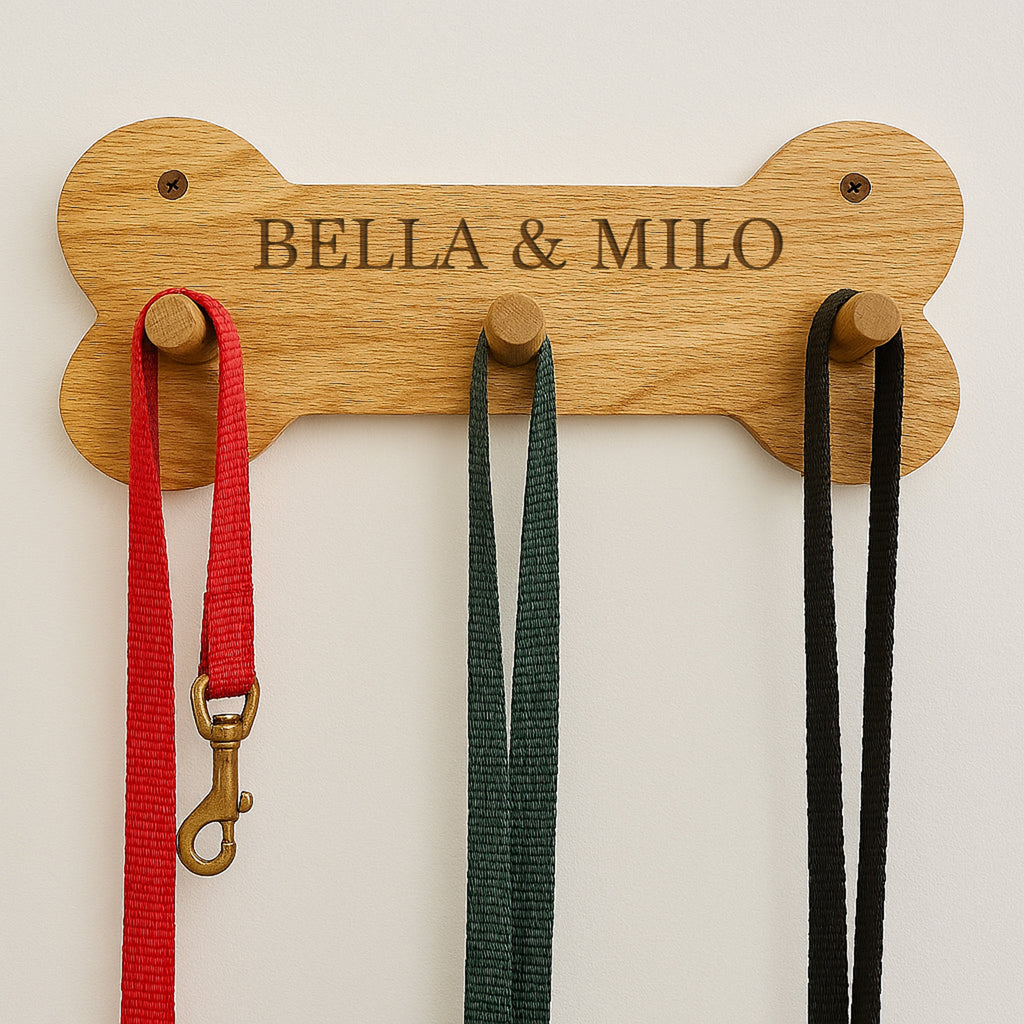 Wooden bone-shaped leash holder with 'Bella & Milo' engraving, holding three leashes.