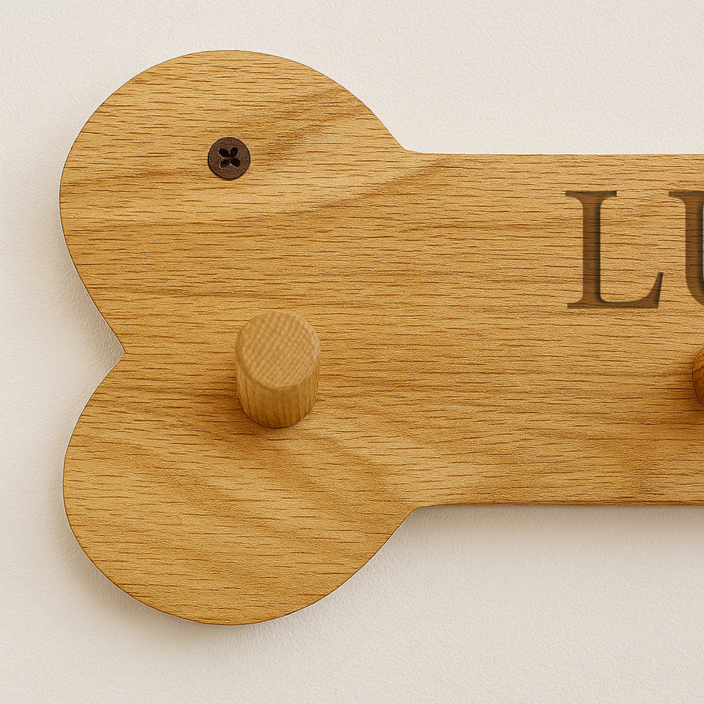 Wooden dog bone-shaped tag with 'LUCY' engraved on a white background
