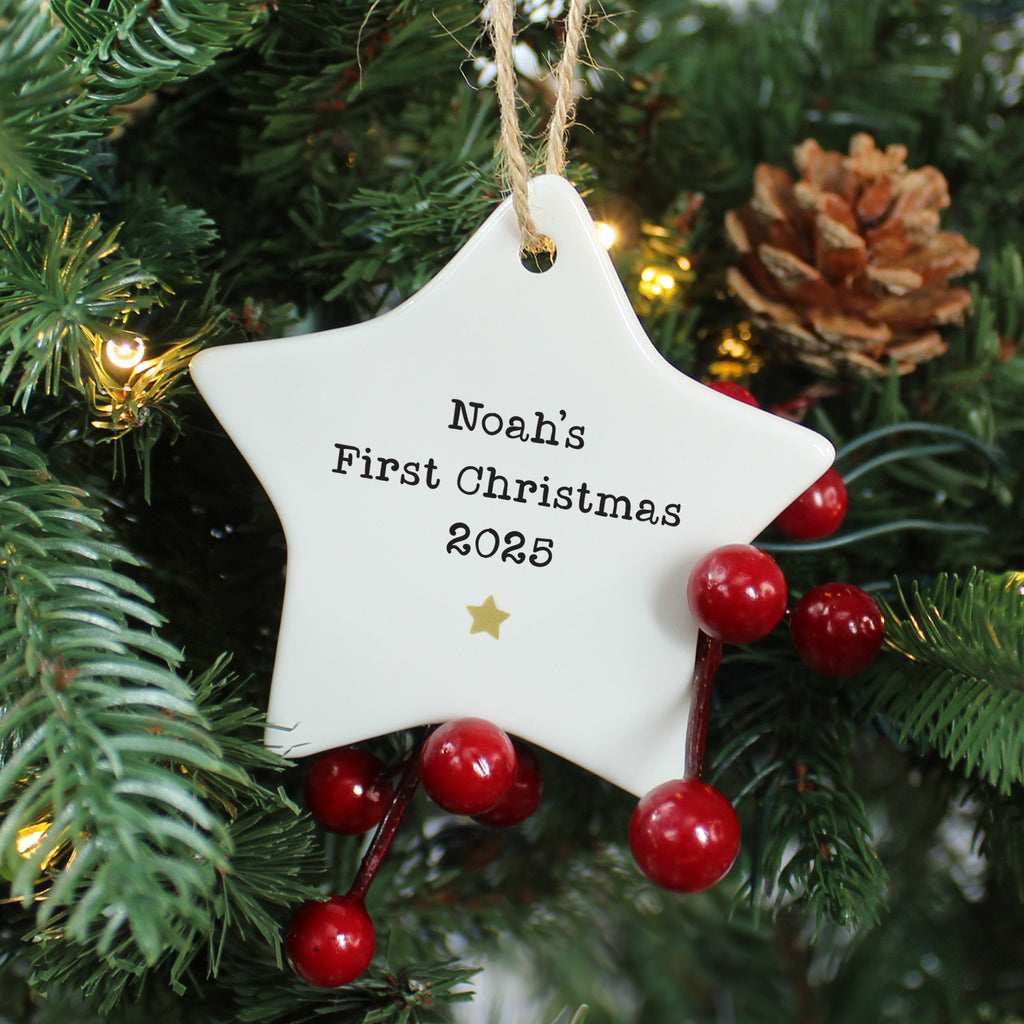Star-shaped ornament with 'Noah's First Christmas 2023' text on a Christmas tree.