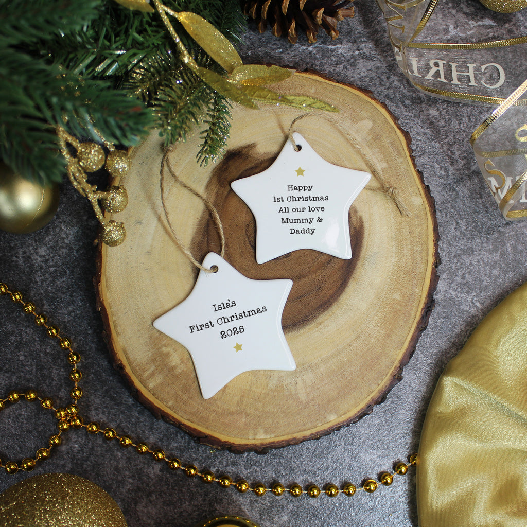 Personalized Christmas star ornaments on a wooden slice with festive decorations.