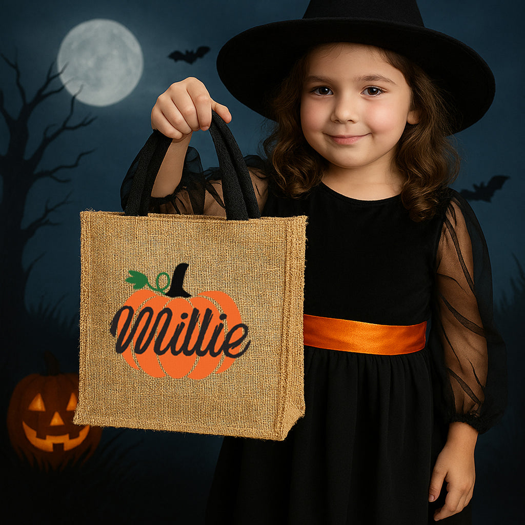 Young girl in Halloween costume holding a personalized bag with a pumpkin design and name 'Millie'.