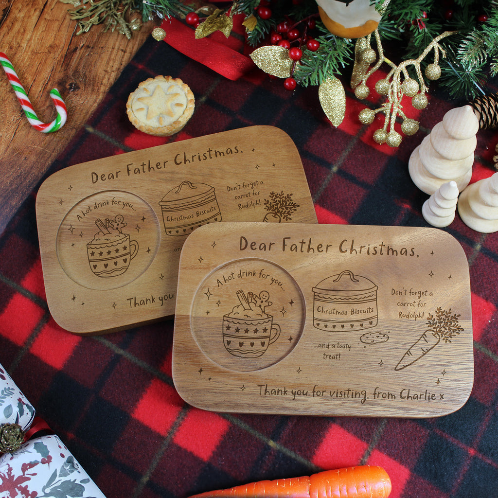 Two wooden Christmas platters with engraved designs on a festive tablecloth.