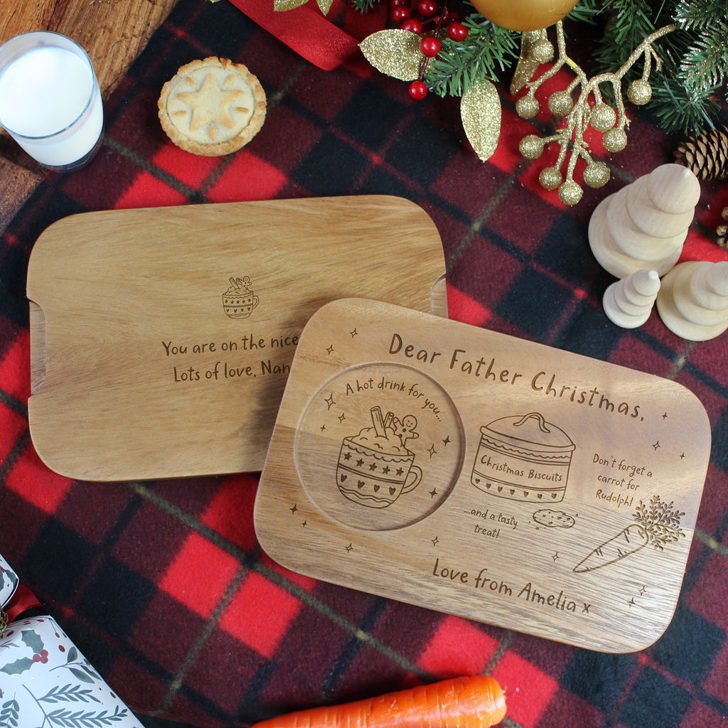 Two wooden platters with engraved messages on a festive tablecloth.