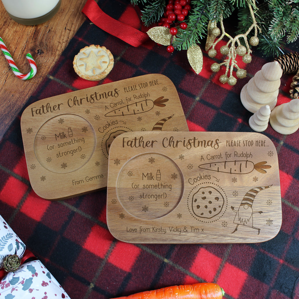 Two wooden Christmas Eve boards with engraved text on a festive background.