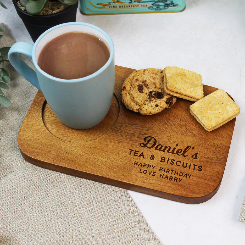 Mug of tea with cookies on a wooden board personalized for 'Daniel's Tea & Biscuits'.