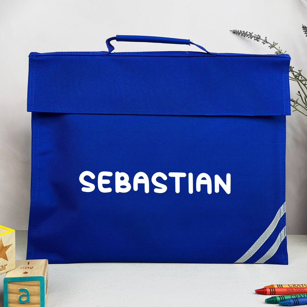 Blue book bag with 'SEBASTIAN' printed on it, surrounded by children's toys and stationery items.