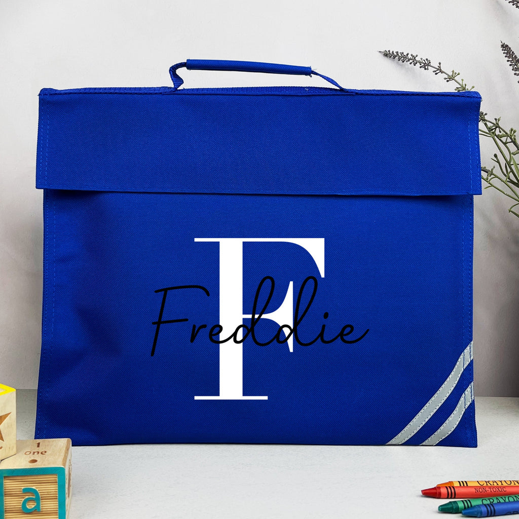 Blue box with 'Freddie' and a white letter 'P' on a white surface with stationery items.