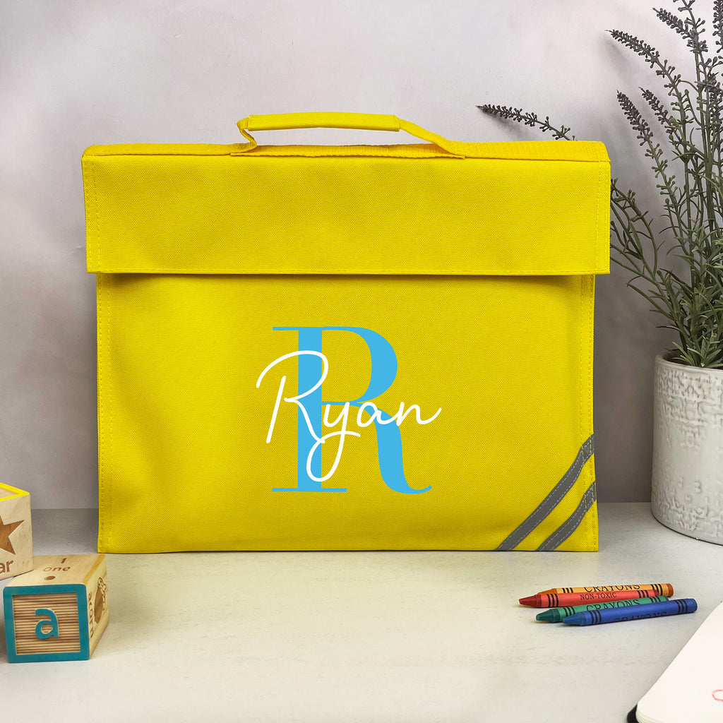Yellow storage box with 'Ryan' monogram on a white surface with crayons and a plant.