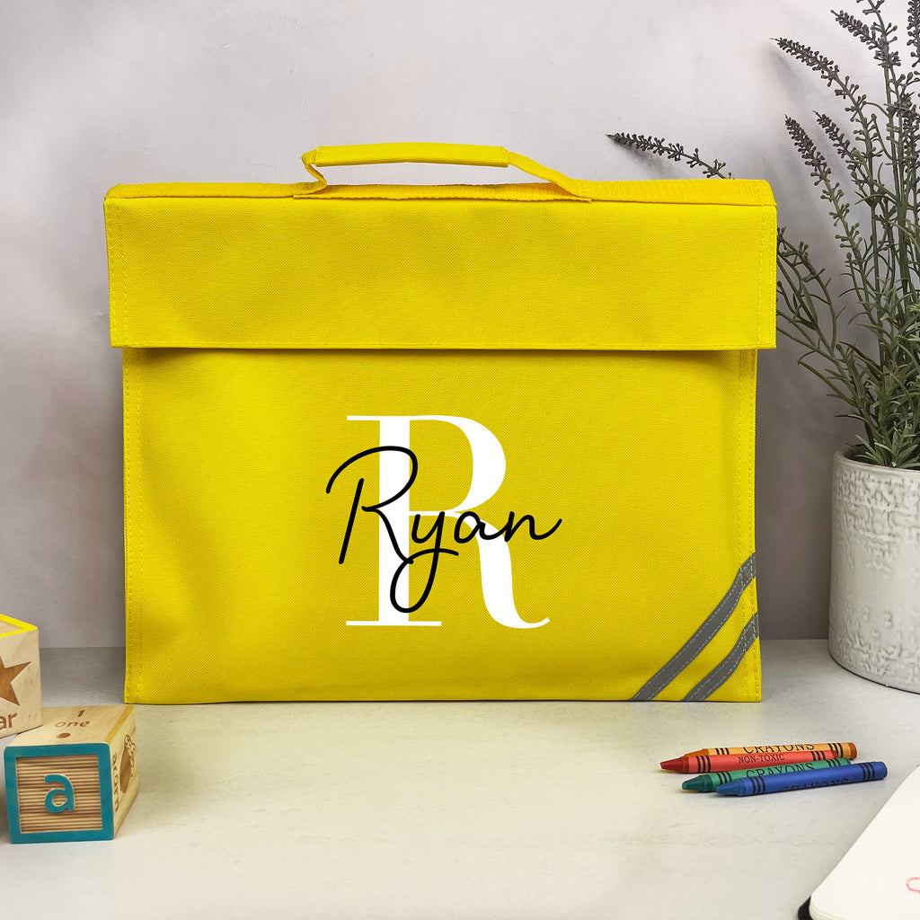 Yellow box with 'Ryan' monogram on a white surface with crayons and a plant in the background
