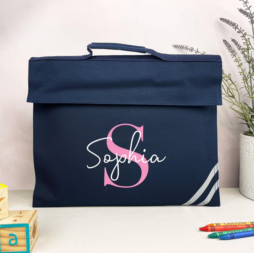 Navy blue bag with pink and white 'Sophia' design on a light surface with a plant in the background