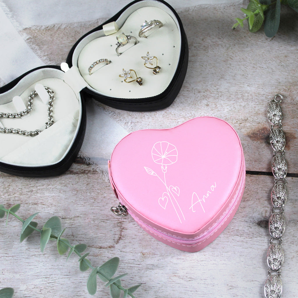 Heart-shaped jewelry box with jewelry on a wooden surface