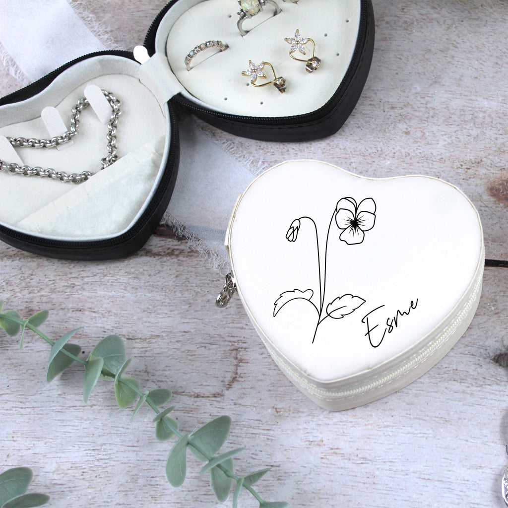 Heart-shaped jewelry box with floral design and 'Esme' inscription on a wooden surface.