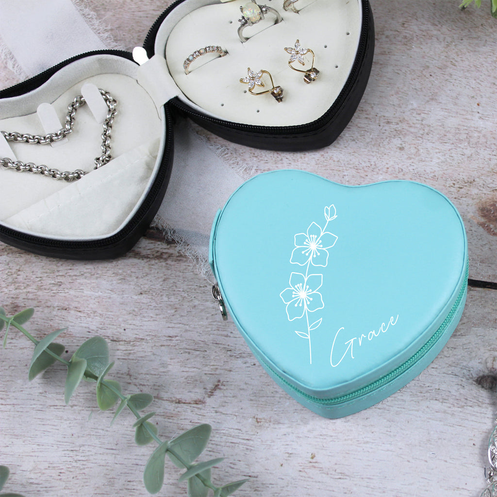 Heart-shaped turquoise jewelry case with floral design and 'Grace' text on a wooden surface.