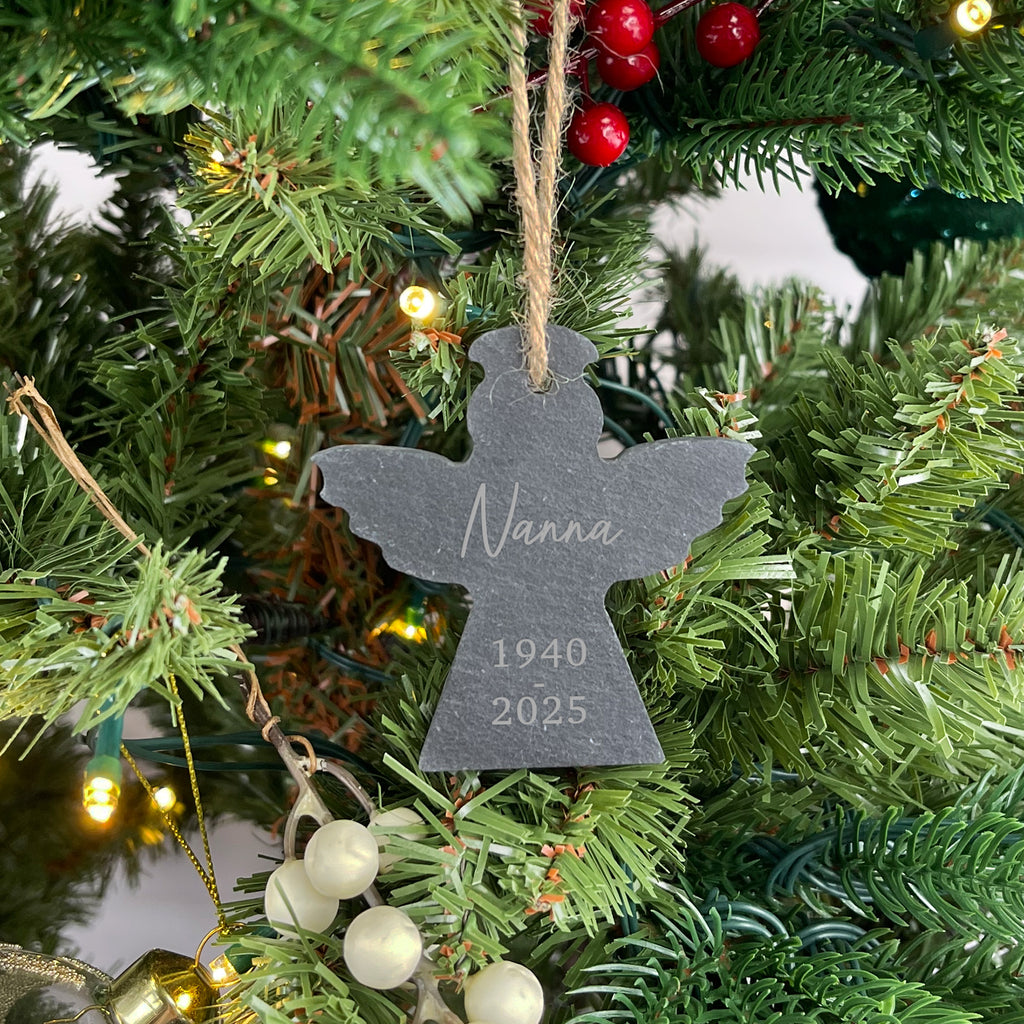Decorative angel ornament with 'Nanna 1940-2025' on a Christmas tree.