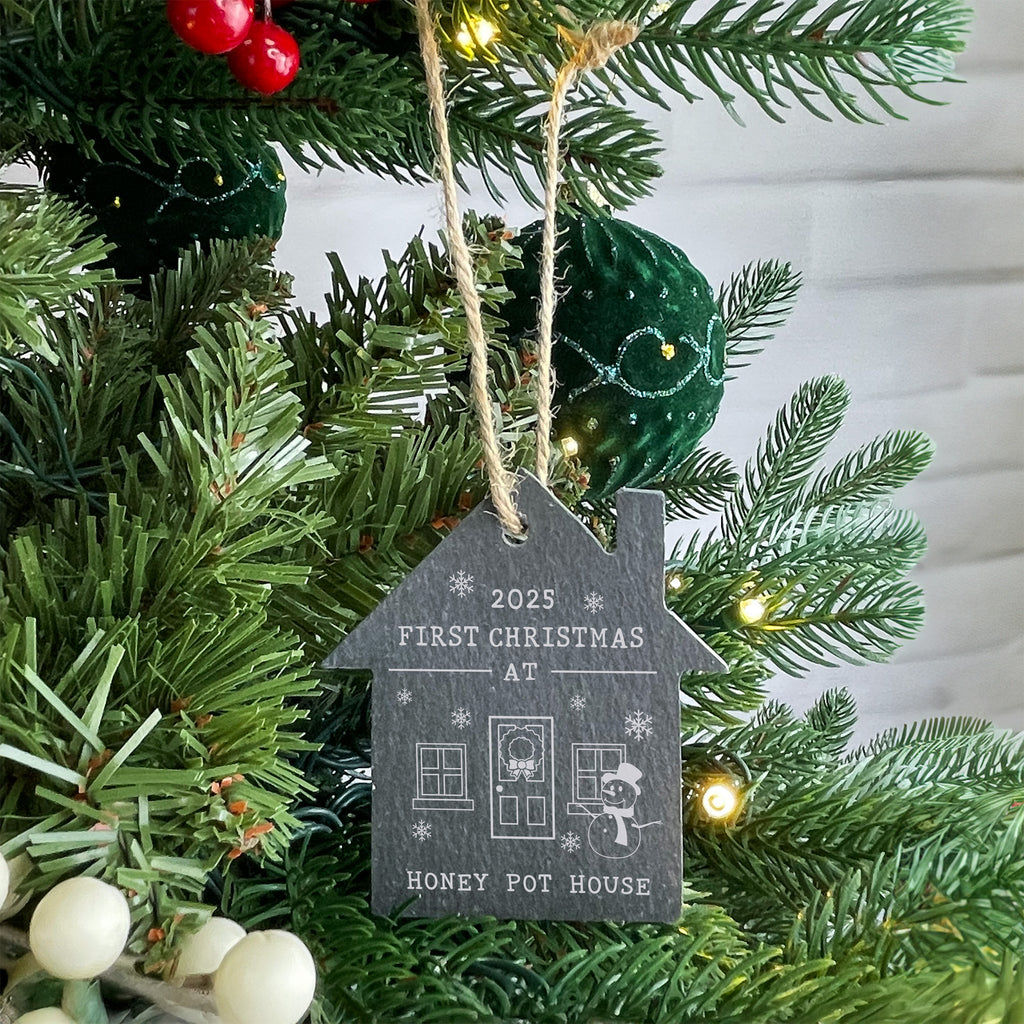 Decorative ornament on a Christmas tree with text '2025 First Christmas at Honey Pot House'.