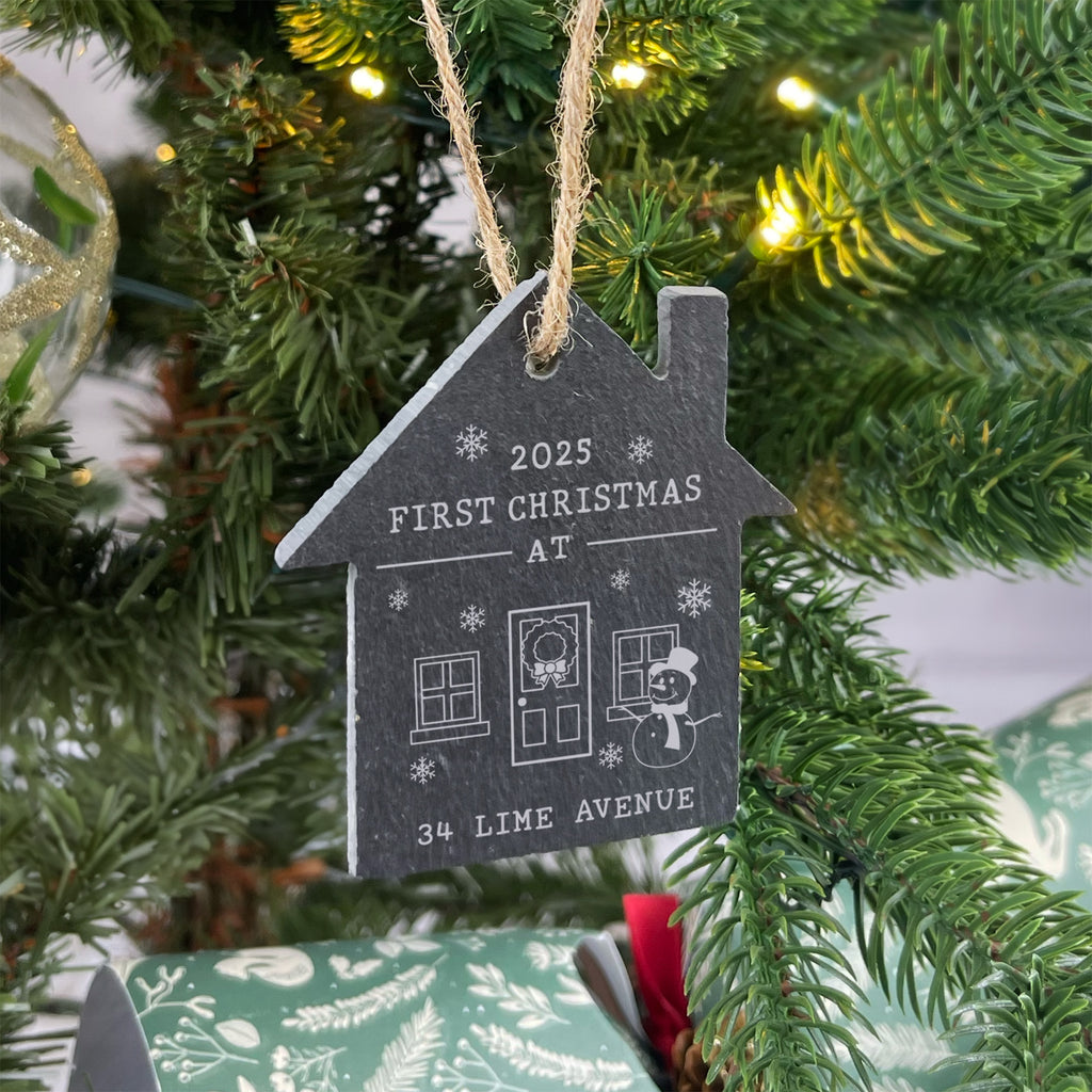 Decorative ornament for a Christmas tree with '2025 First Christmas at' text on a house-shaped slate.