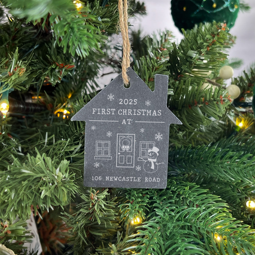 Decorative ornament on a Christmas tree with 'First Christmas at' text
