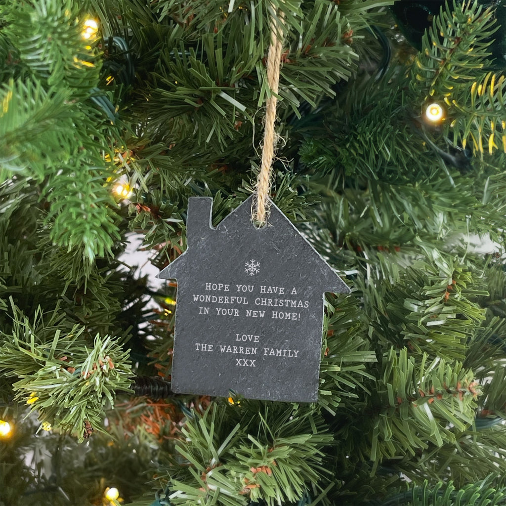 House-shaped Christmas ornament with a message on a decorated tree