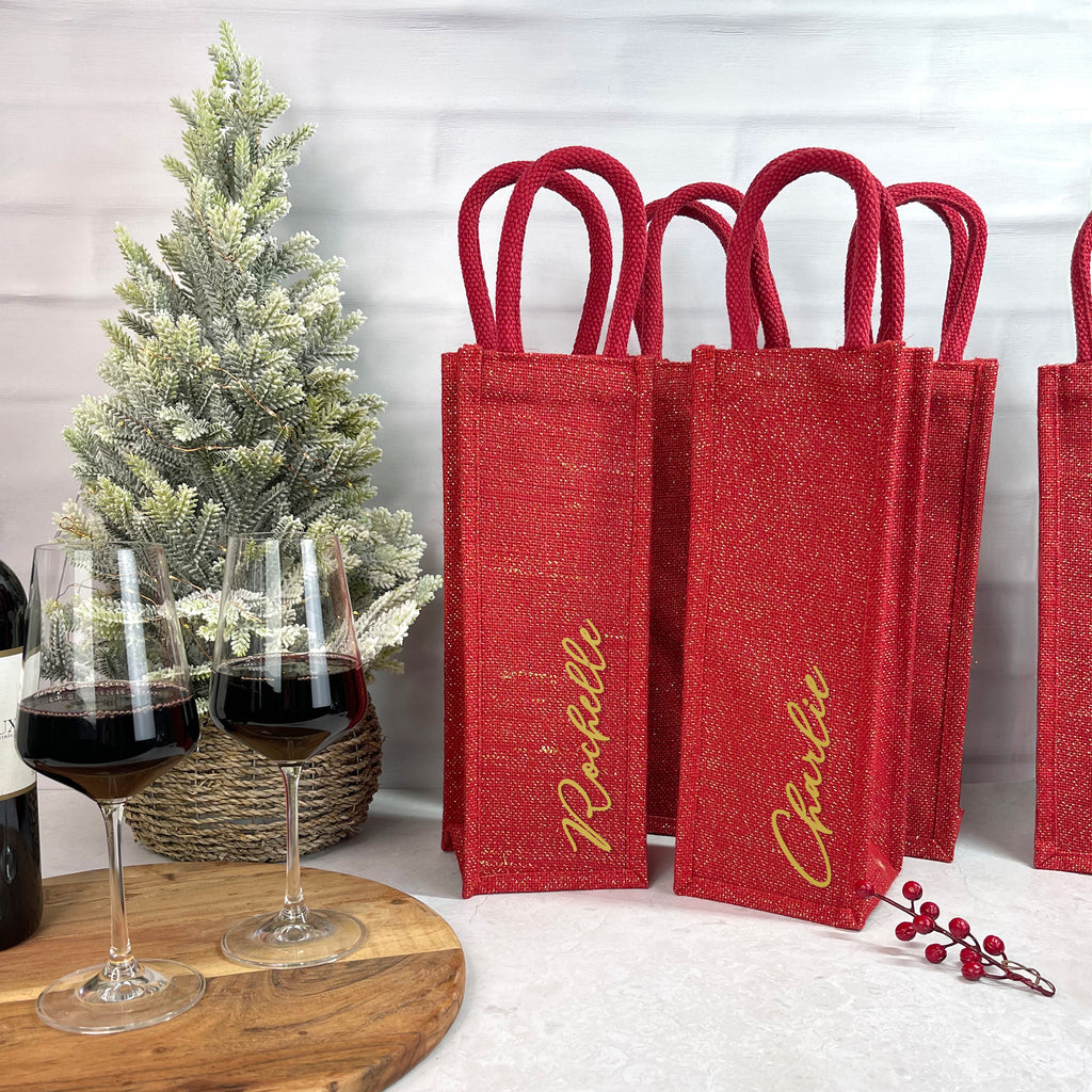 Red wine bags with 'Nathalie' branding next to two glasses of red wine and a small Christmas tree.