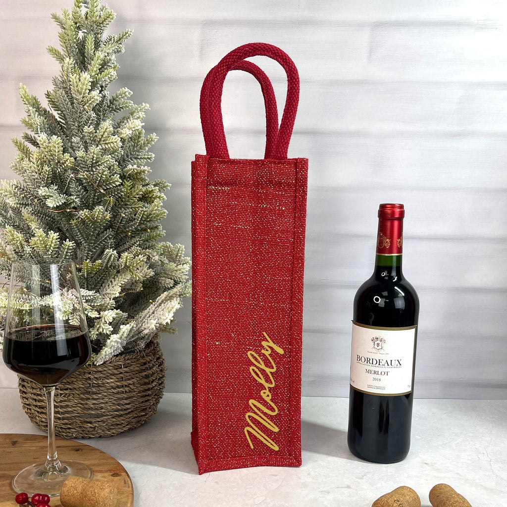 Red wine bottle bag with 'Molly' branding next to a bottle of Bordeaux Merlot and a glass of red wine.
